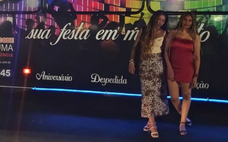 Duas amigas de pé no ônibus balada